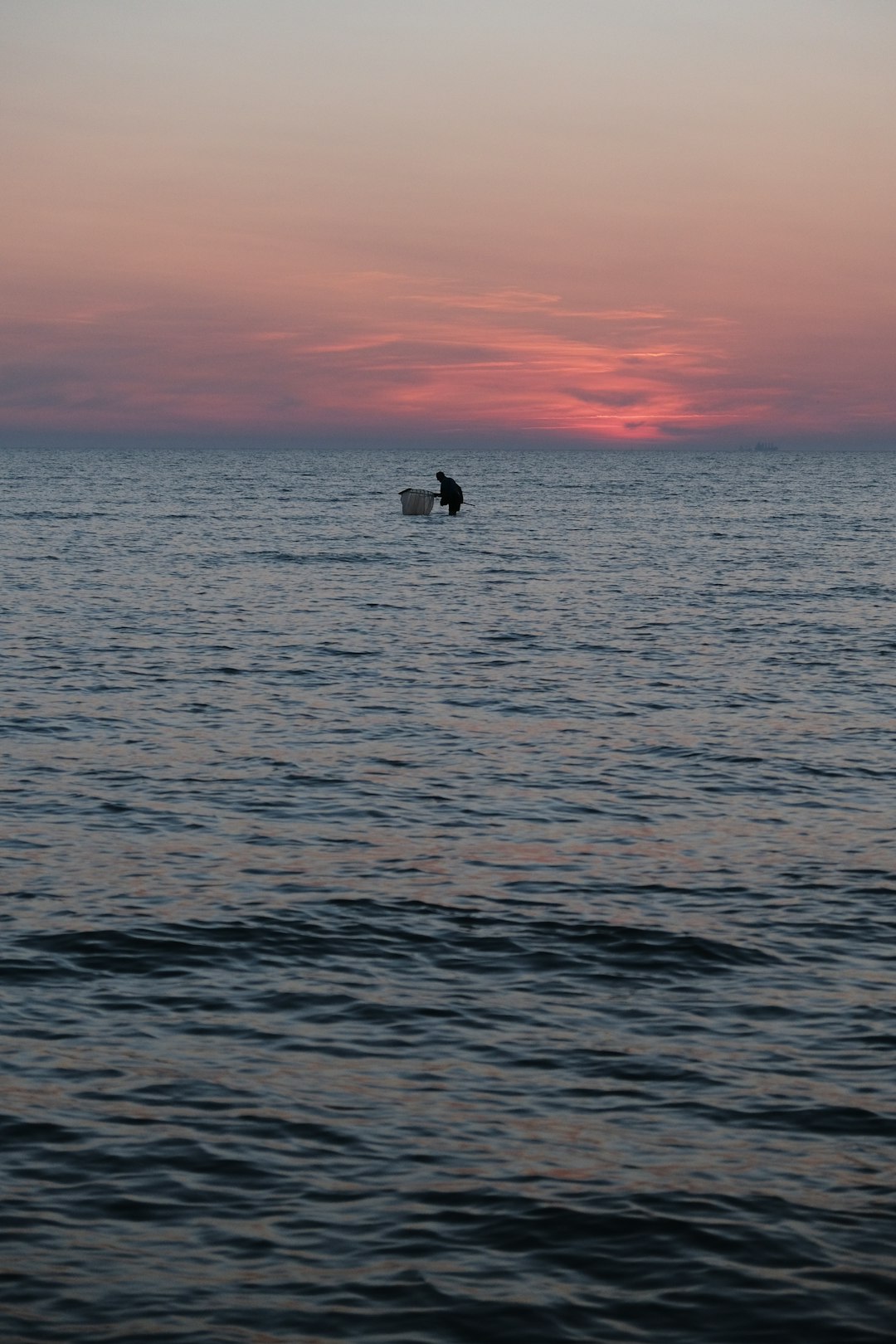 silhouette of person on boat on sea during sunset