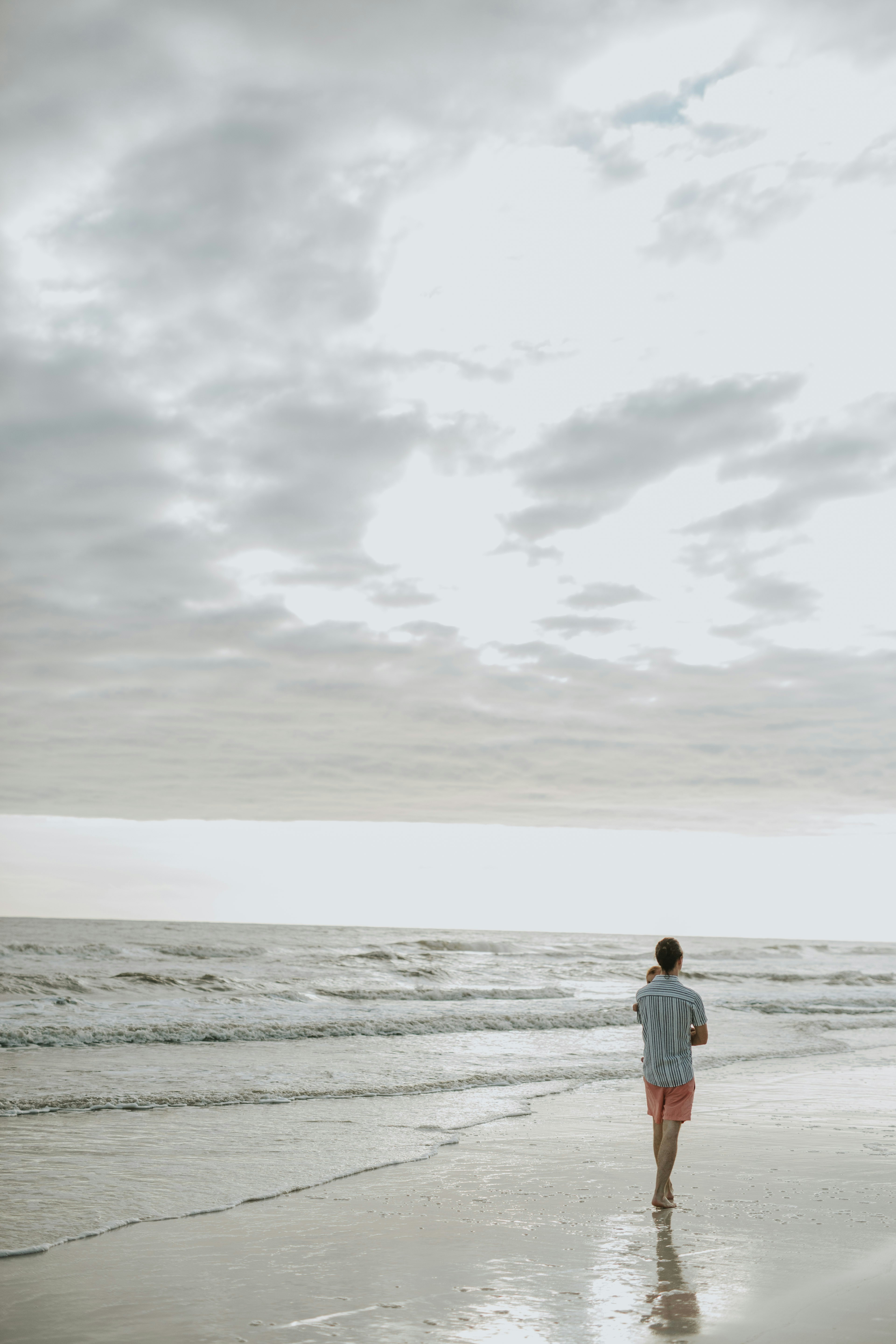 Mujer con vestido blanco de pie en la playa durante el día