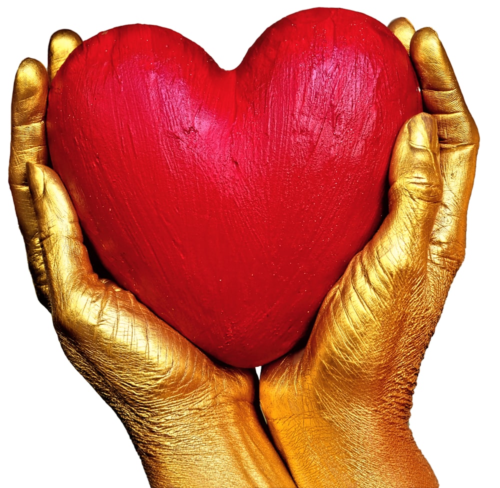 person holding red heart shaped ornament