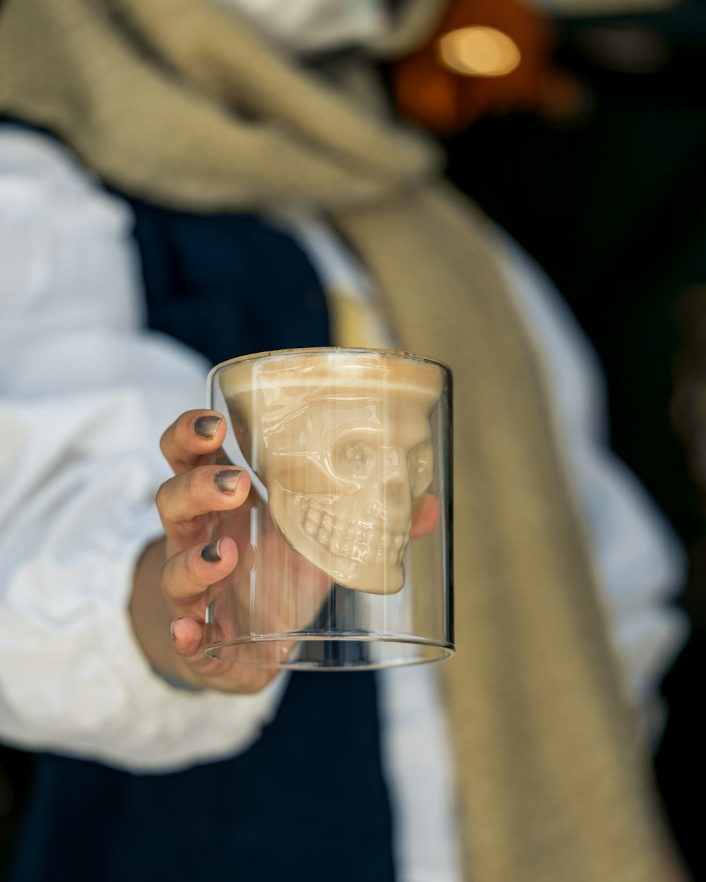 Persona sosteniendo un vaso transparente