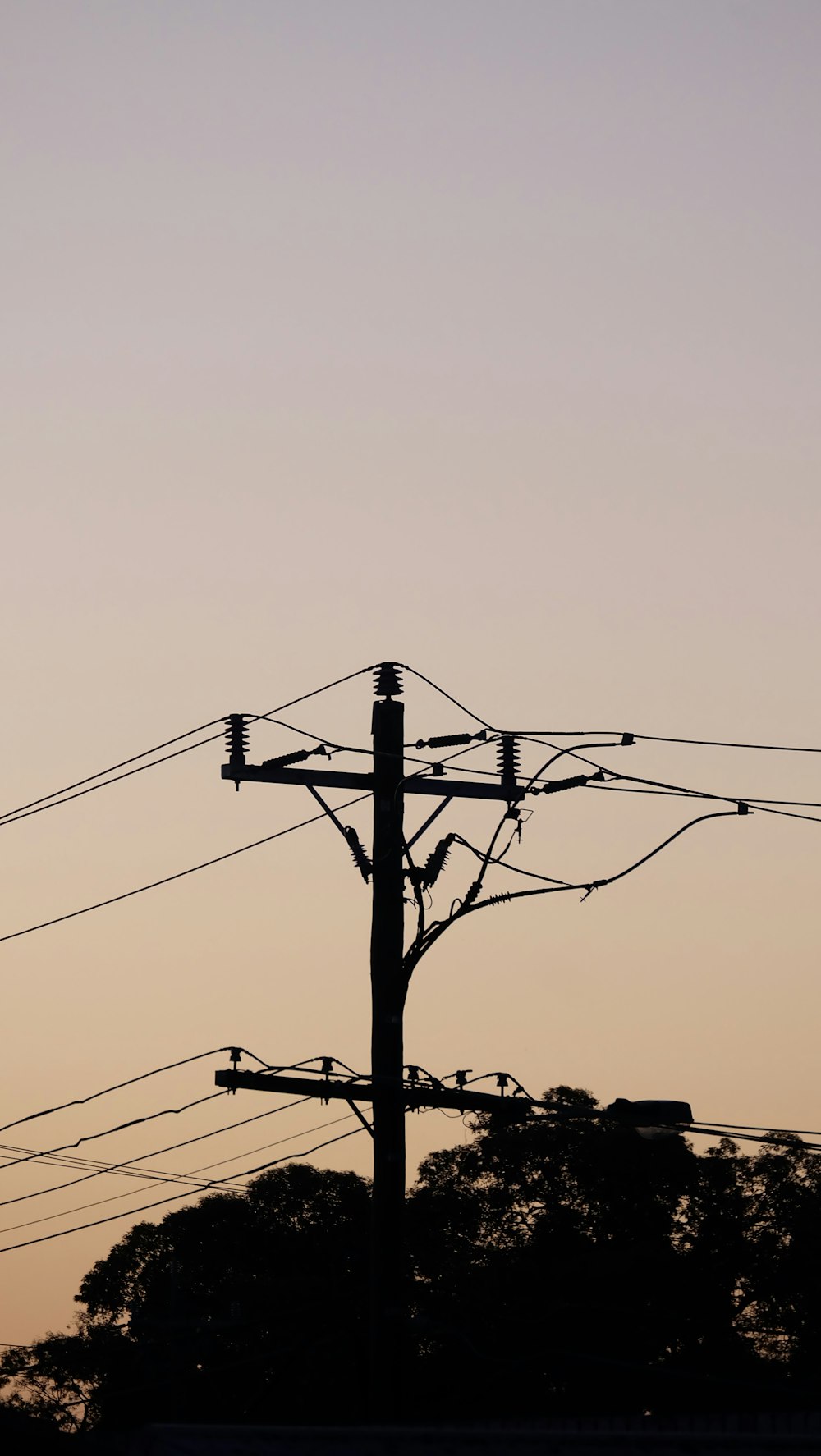 poteau électrique noir sous ciel blanc