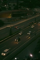 Nighttime view of a large highway project with illuminated mechanical installations underway.