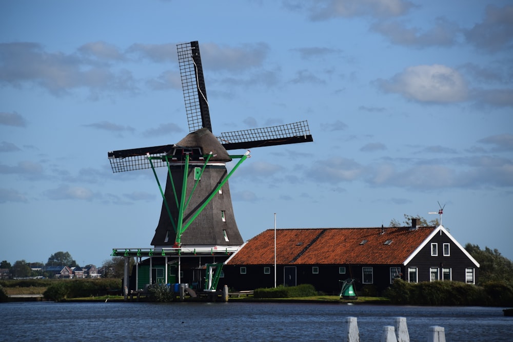 brown and black windmill near body of water during daytime