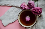 A soft faux-cashmere shawl folded elegantly beside a steaming cup of tea.