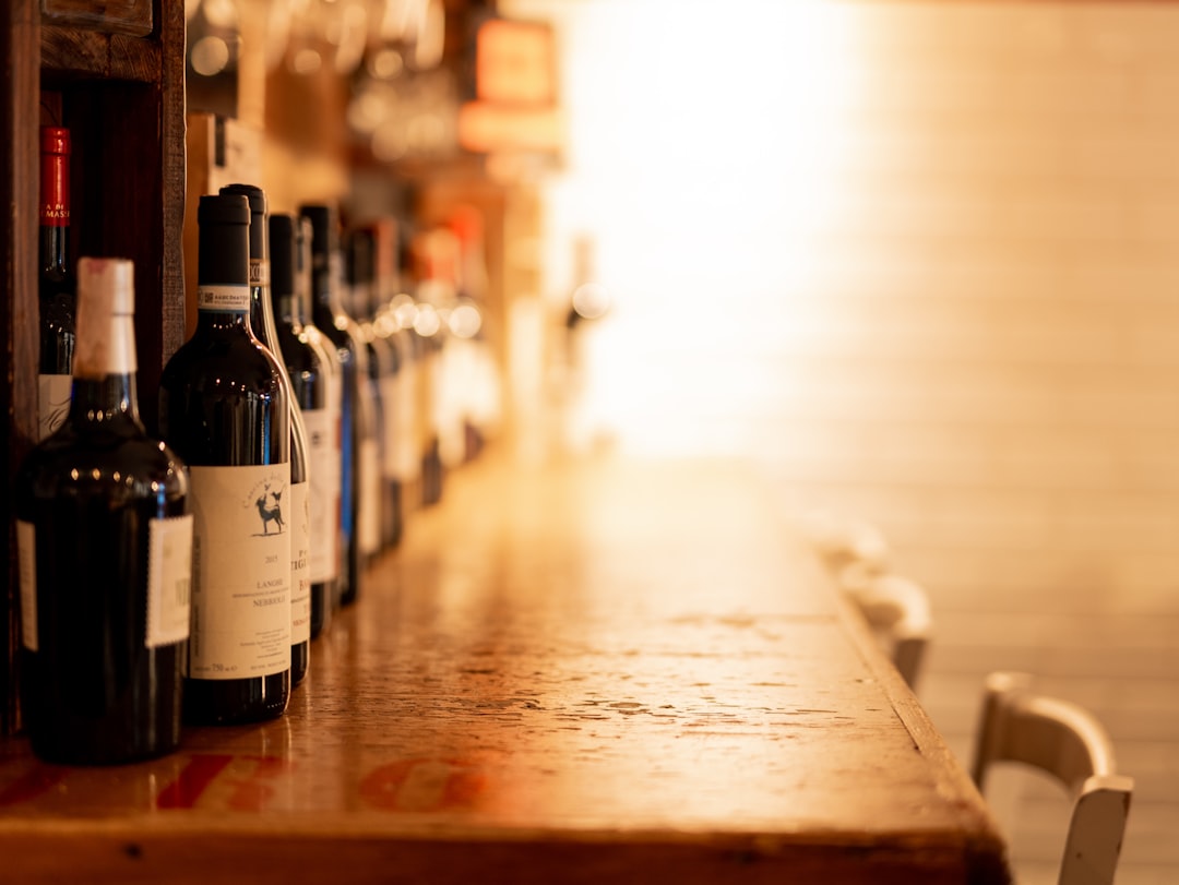 selective focus photography of wine bottles on wooden table