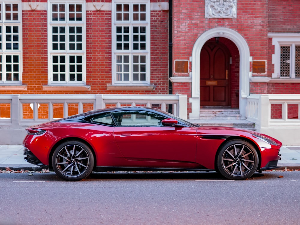 red coupe parked in front of brown brick building