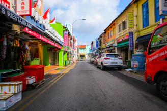 Colorful storefronts lining a lively street filled with customers.