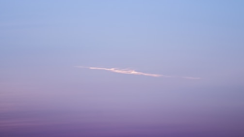 A serene blend of deep purple and blue hues with a subtle silhouette of Lord Shiva meditating under a starry sky.