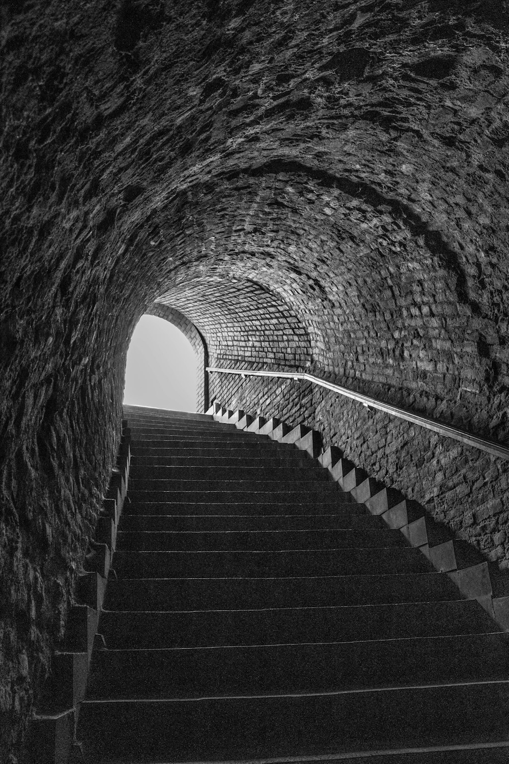 grayscale photo of concrete tunnel