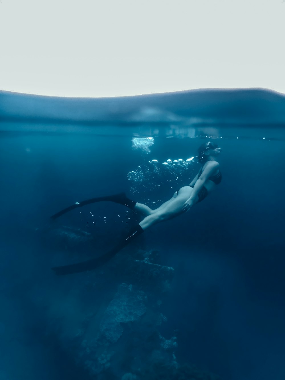 woman in black bikini swimming in the water