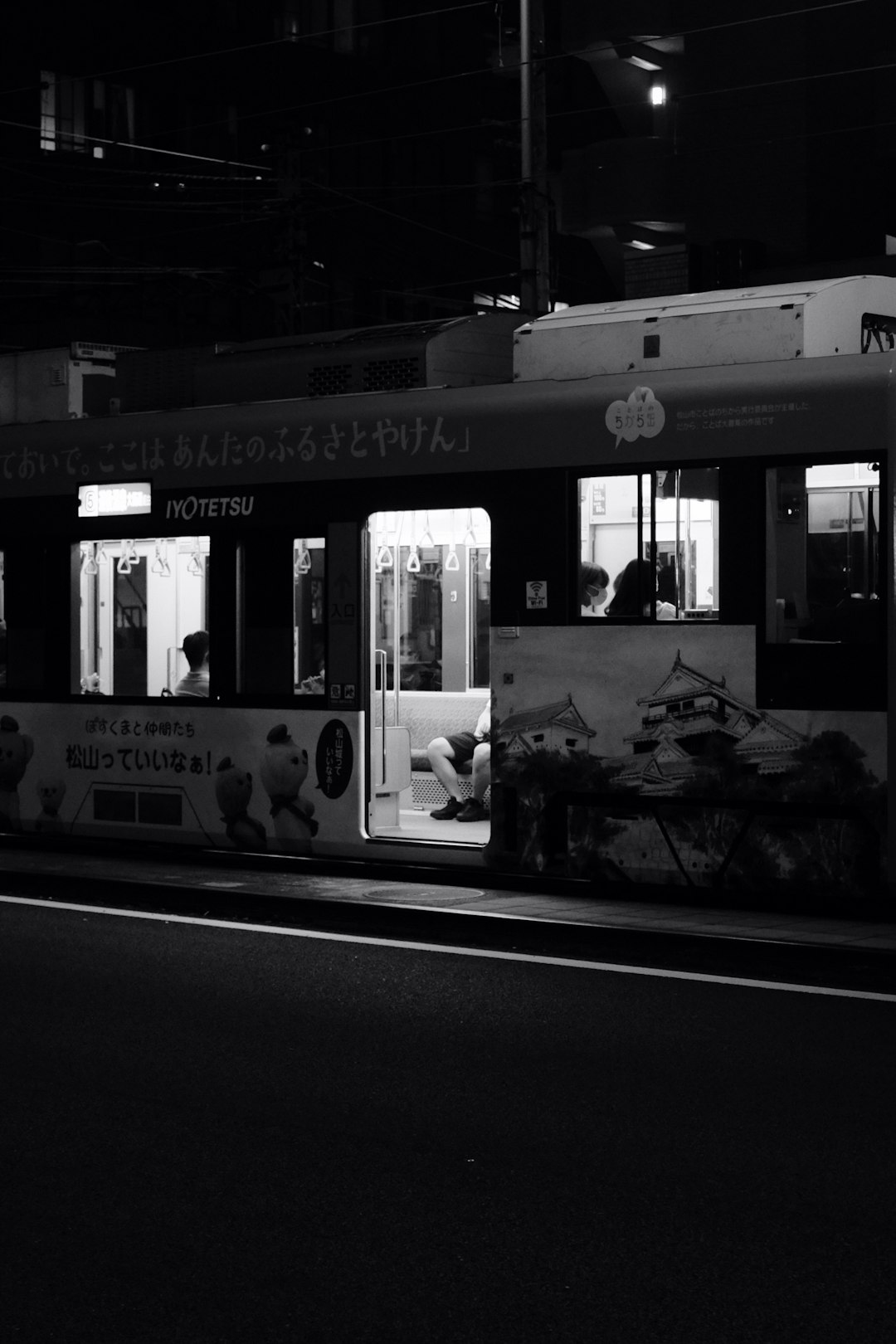 grayscale photo of people riding train
