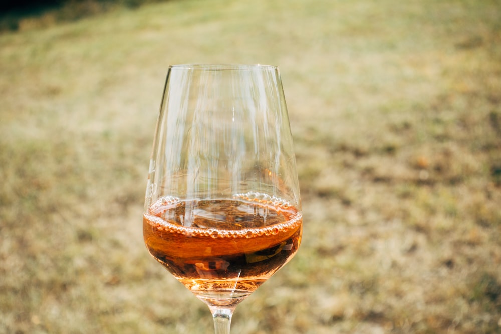 copo de vinho transparente com líquido castanho