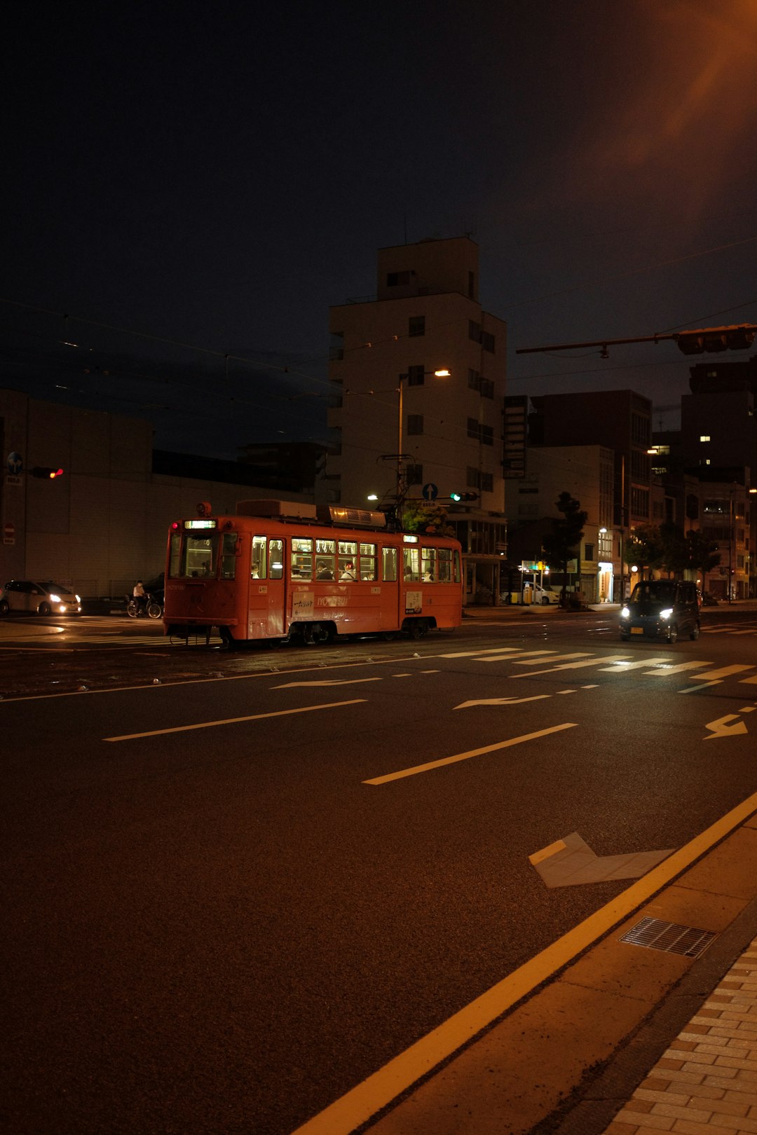 red and white tram on road during night time