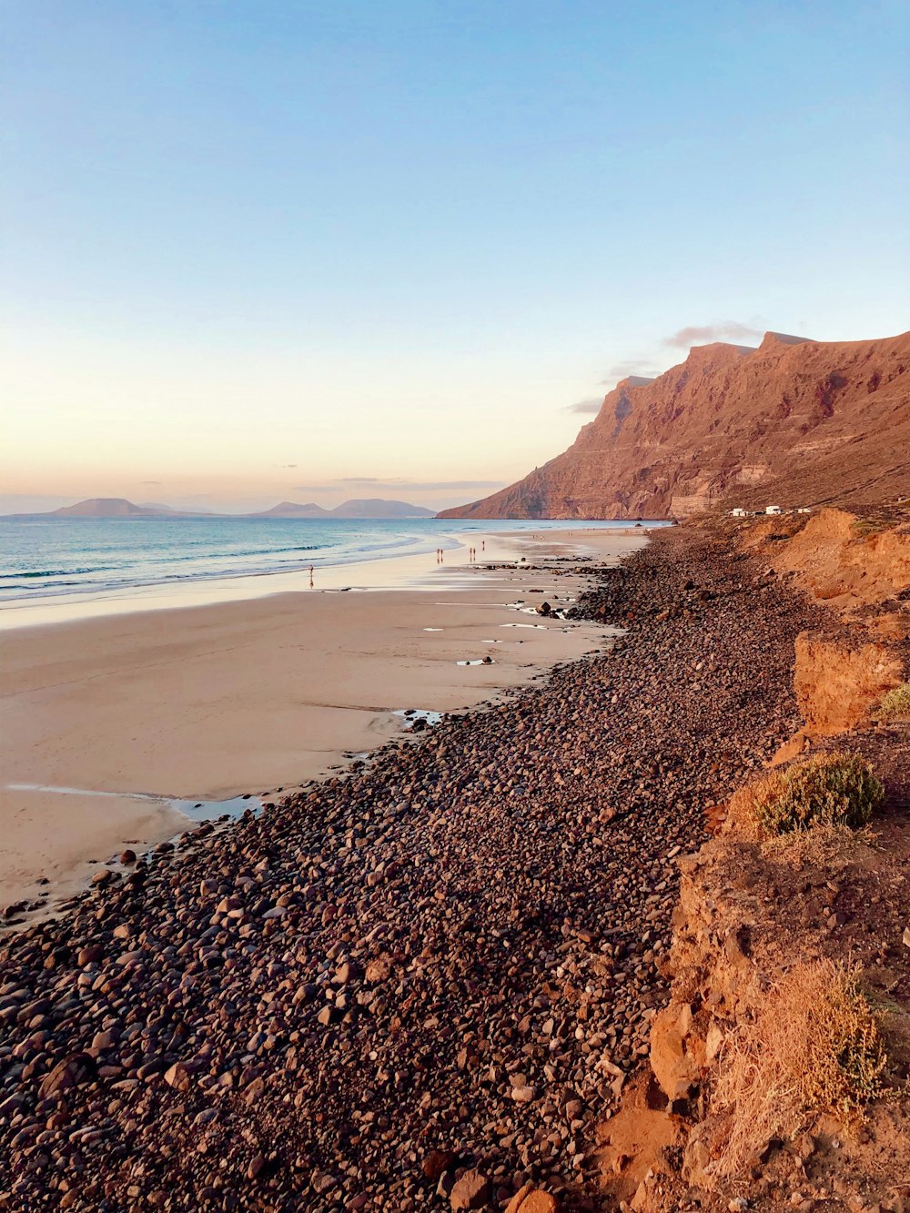 een zee met bergen en een mooi strand