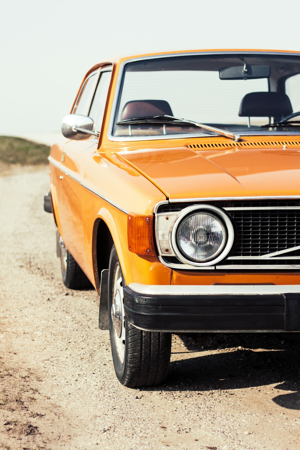 orange car on gray concrete road during daytime