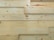 Several overlapping wooden planks with visible grain patterns and knots. The wood has a smooth finish and light natural color.