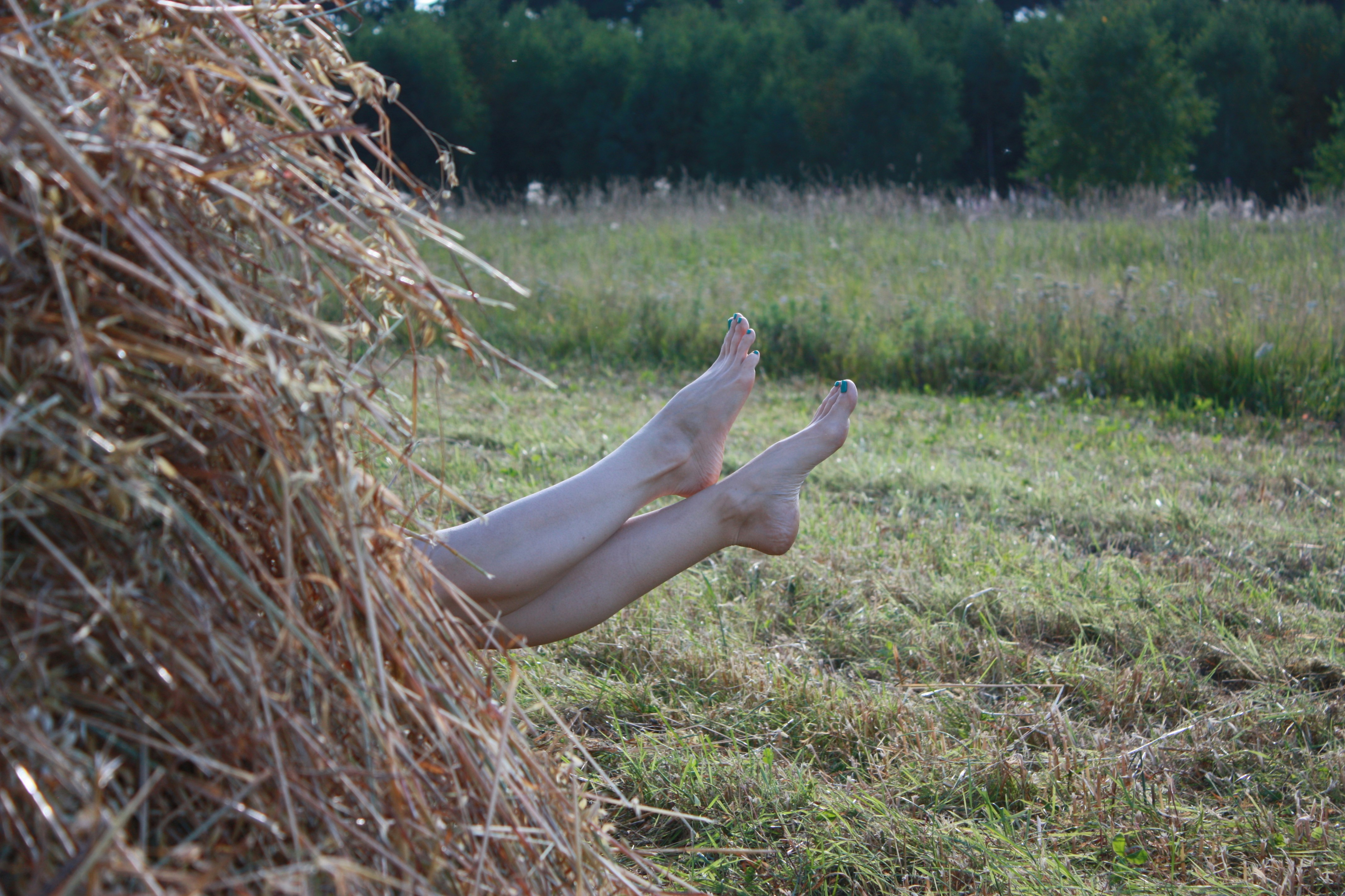 woman in white dress lying on brown grass field during daytime