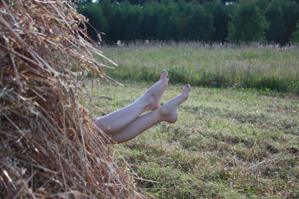 woman in white dress lying on brown grass field during daytime