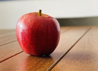 red apple fruit on brown wooden table