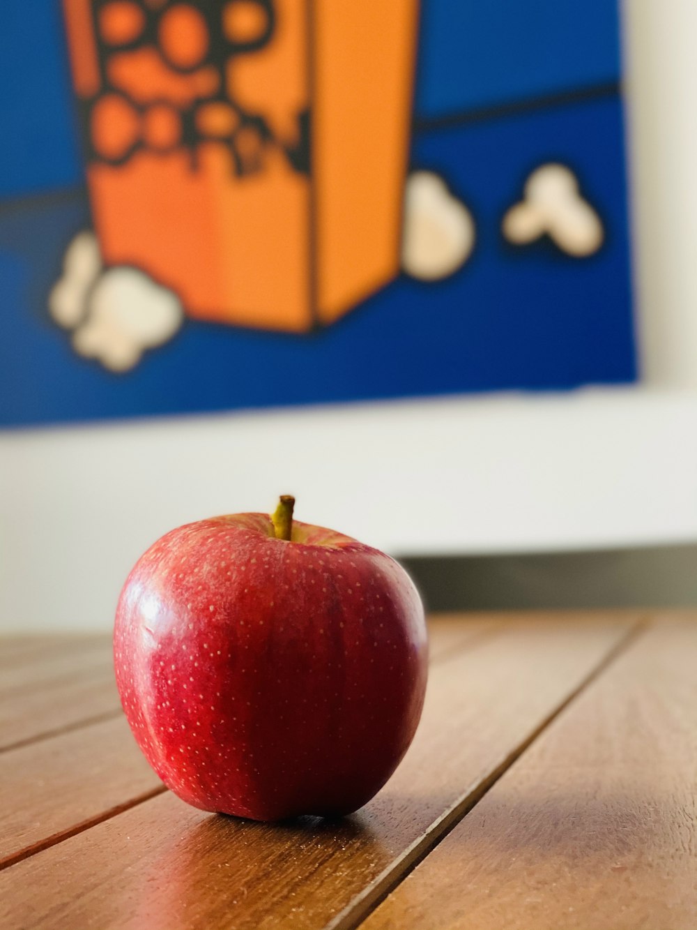 rote Apfelfrucht auf braunem Holztisch