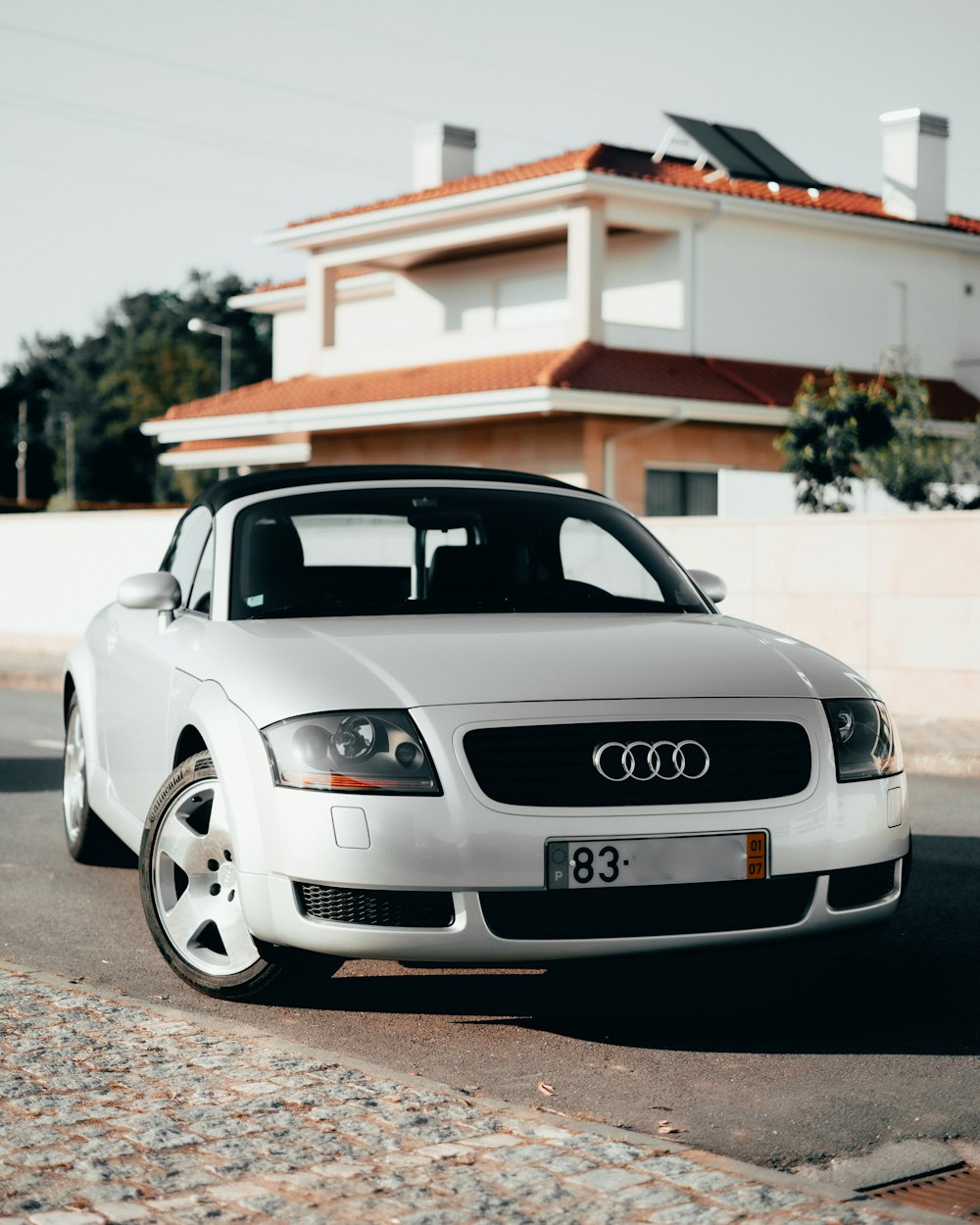 white bmw m 3 coupe parked near brown wooden house during daytime