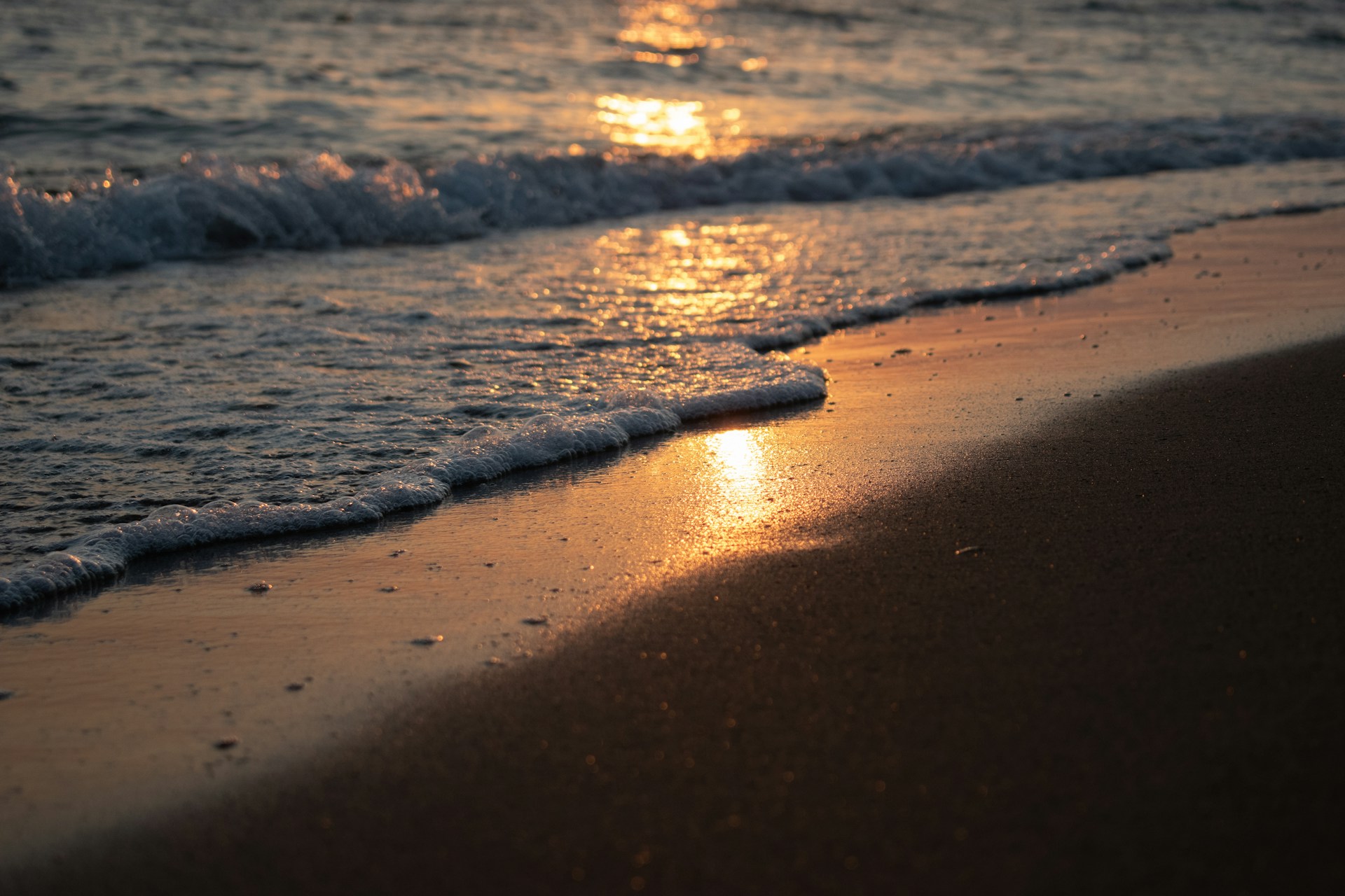 sea waves crashing on shore during sunset