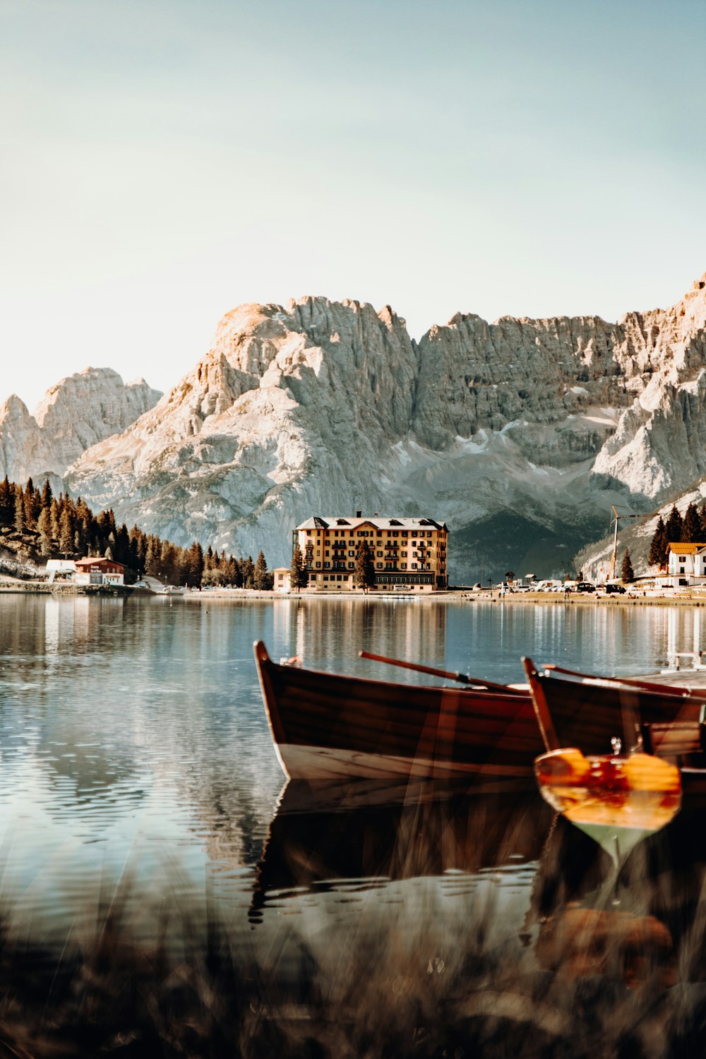 brown wooden boat on lake near mountain during daytime