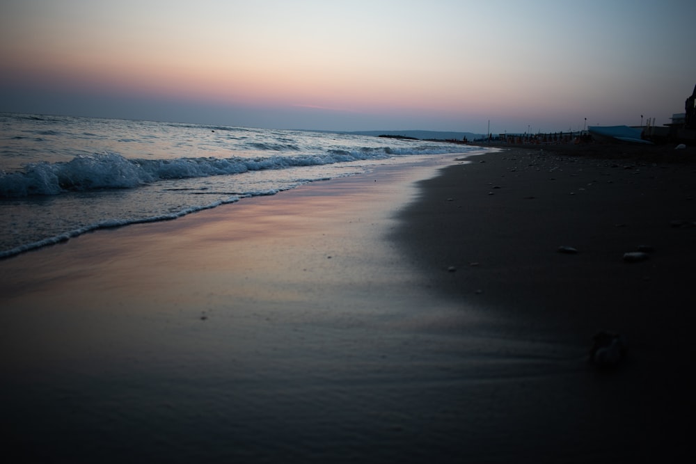 sea waves crashing on shore during sunset