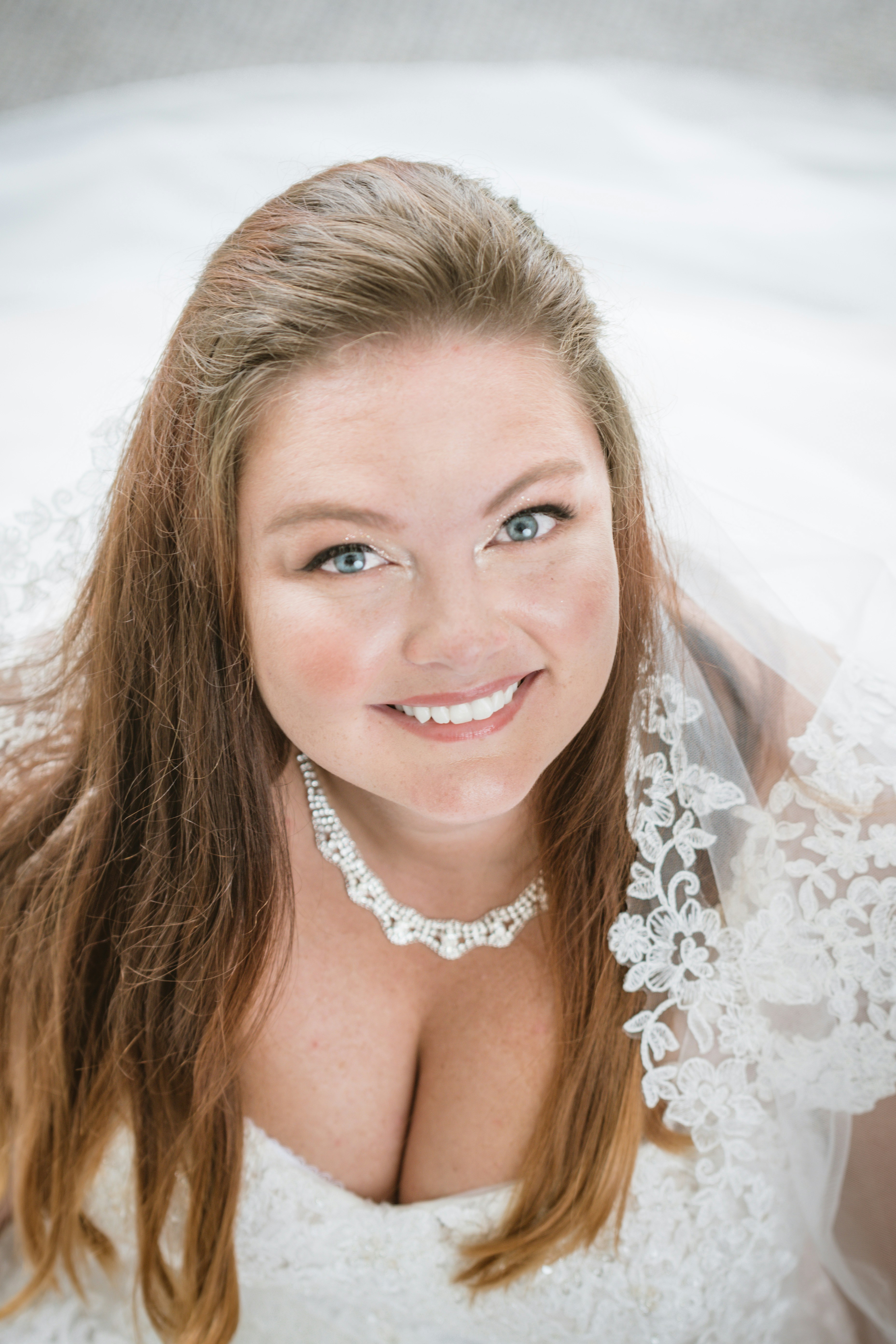 woman in white floral lace dress smiling