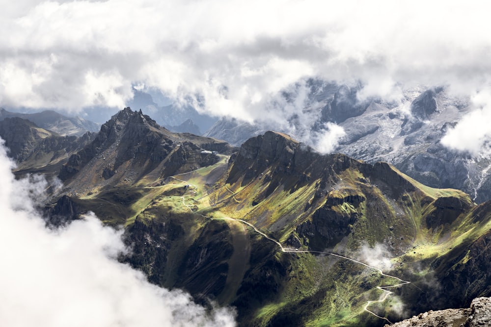 grüne und braune Berge unter weißen Wolken tagsüber