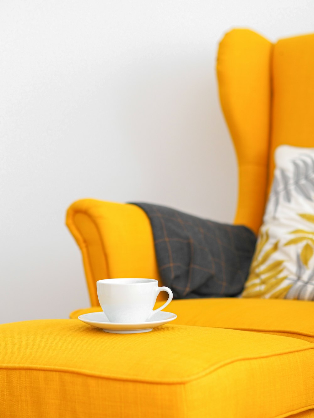 Mujer en pantalones cortos negros sentada en una silla de sofá amarilla