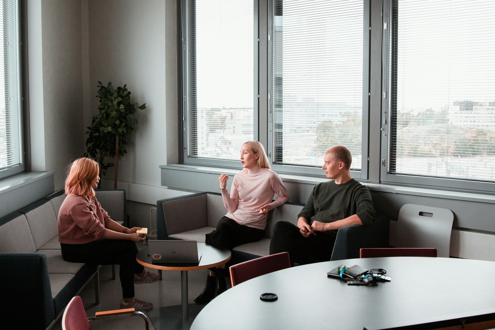 Trois professionnels en cadrage commercial dans un bureau lumineux, scène de décision dirigeant sur le choix entre commercial interne et prestataire externalisé