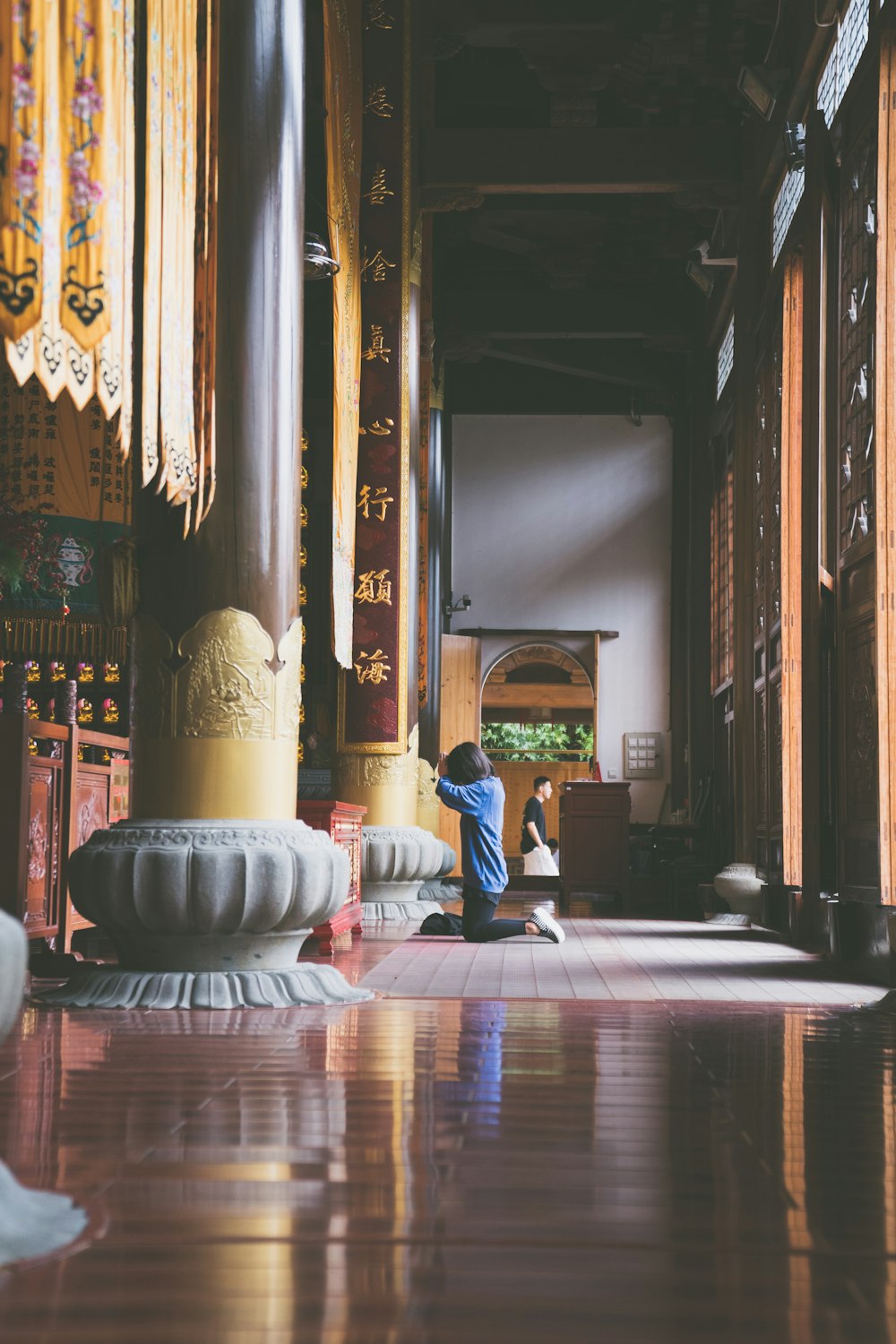 man in blue jacket sitting on white round ottoman