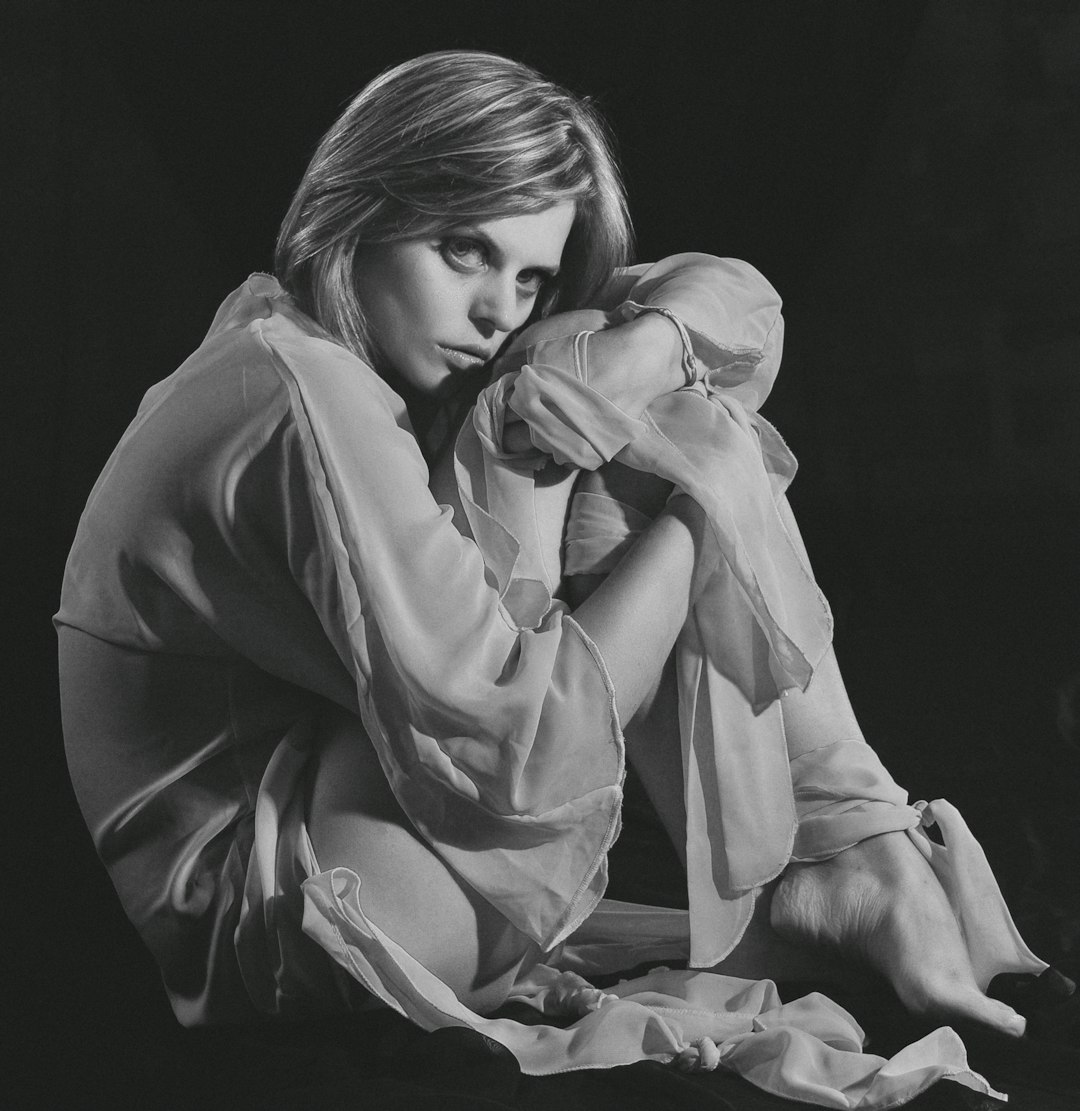 woman in white robe covering her face with her hands