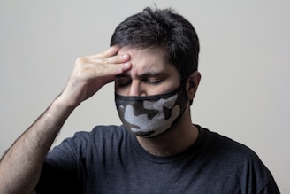 man in black crew neck shirt covering his face with black and white textile