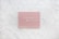 A pink pegboard with the words 'KINDNESS MATTERS' in white letters placed on a hexagonal tiled surface with a marble pattern.