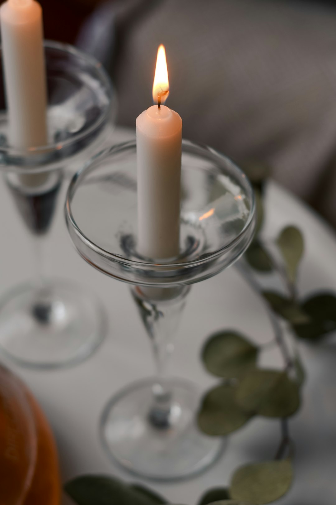 white candle in clear glass candle holder