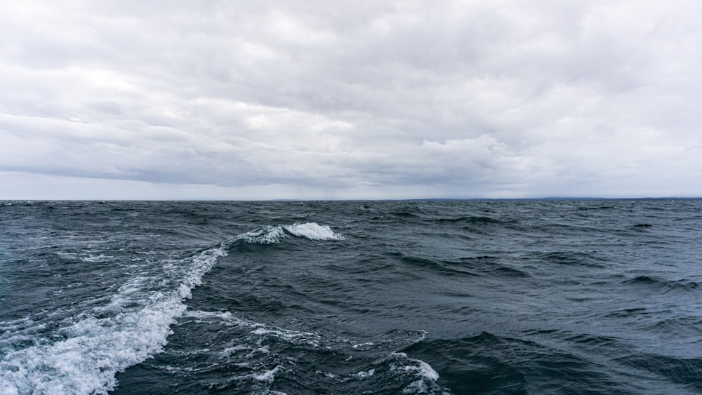 ocean waves under cloudy sky during daytime