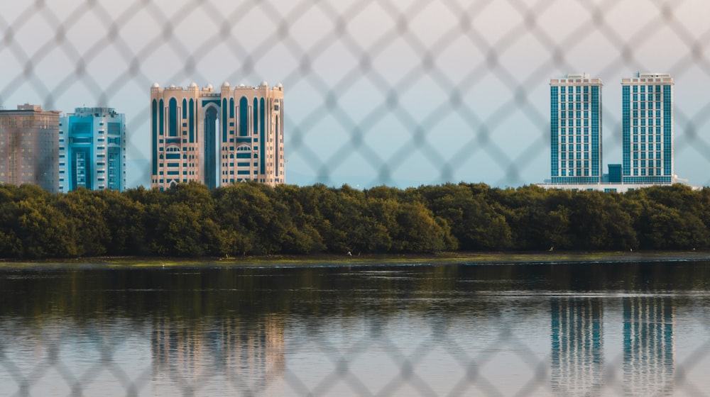 white and brown concrete building near green trees and body of water during daytime