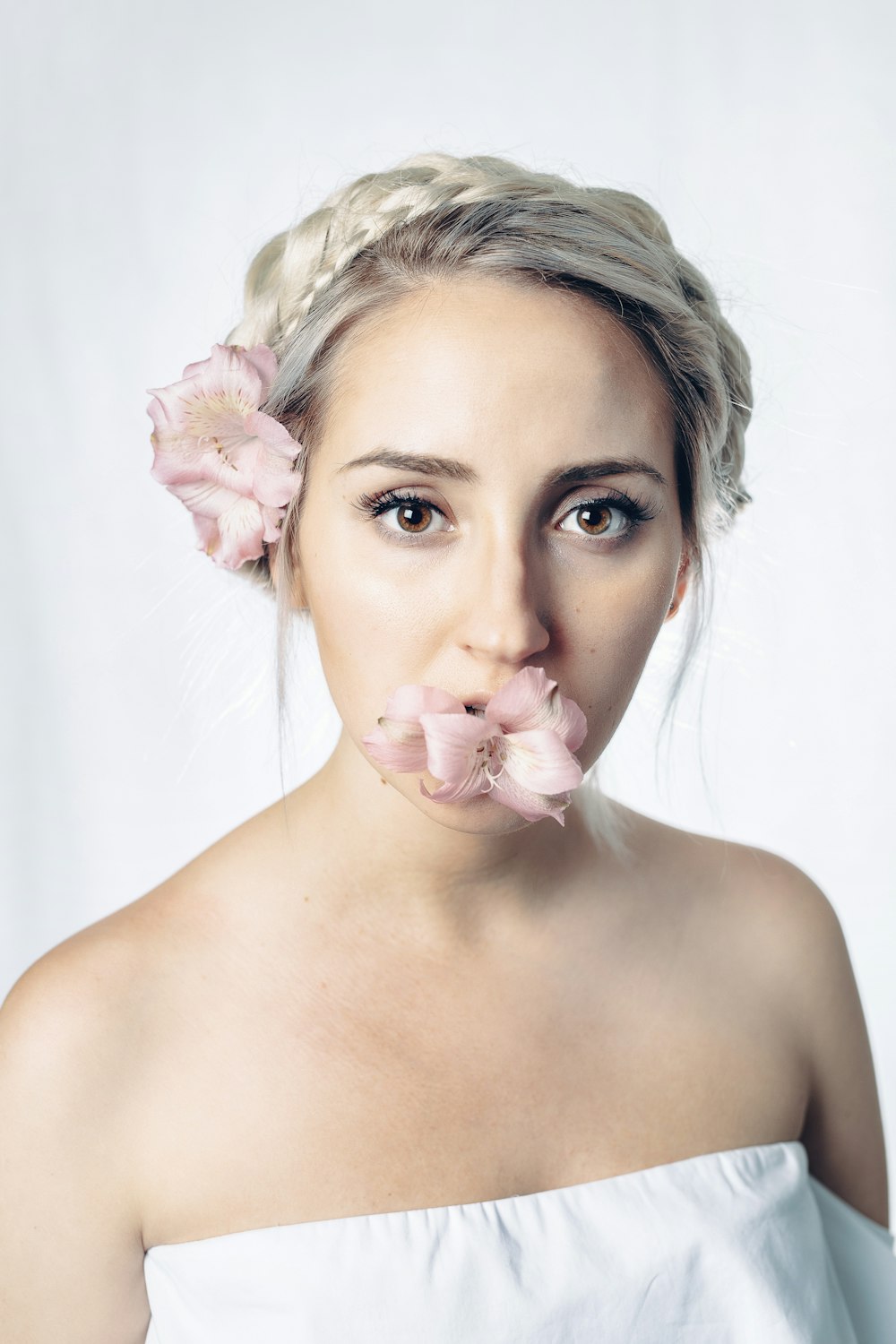 Frau mit rosa Blume im Gesicht