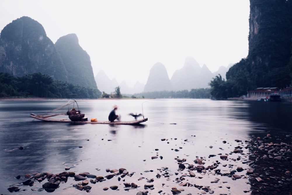 people riding on boat on lake during daytime