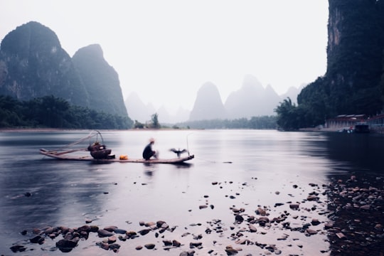 people riding on boat on lake during daytime in Guilin China