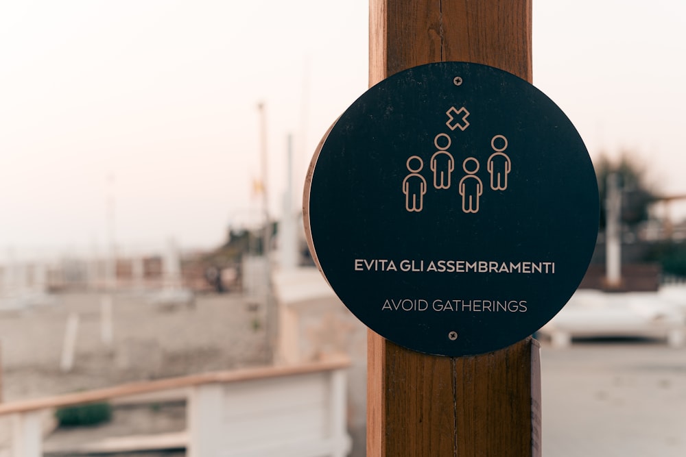 a black sign on a wooden pole that says evatta glassmemberent