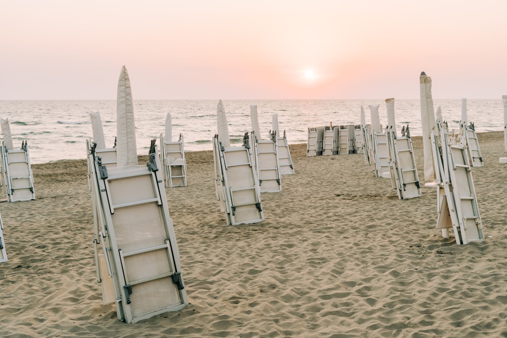 white folding chairs on brown sand during daytime
