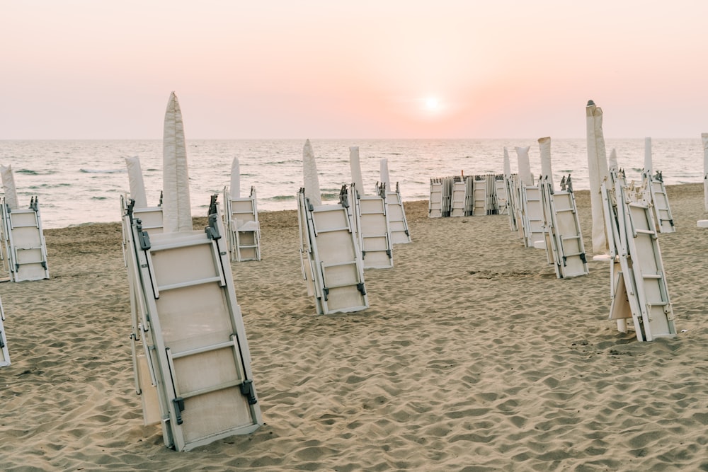 weiße Klappstühle auf braunem Sand tagsüber