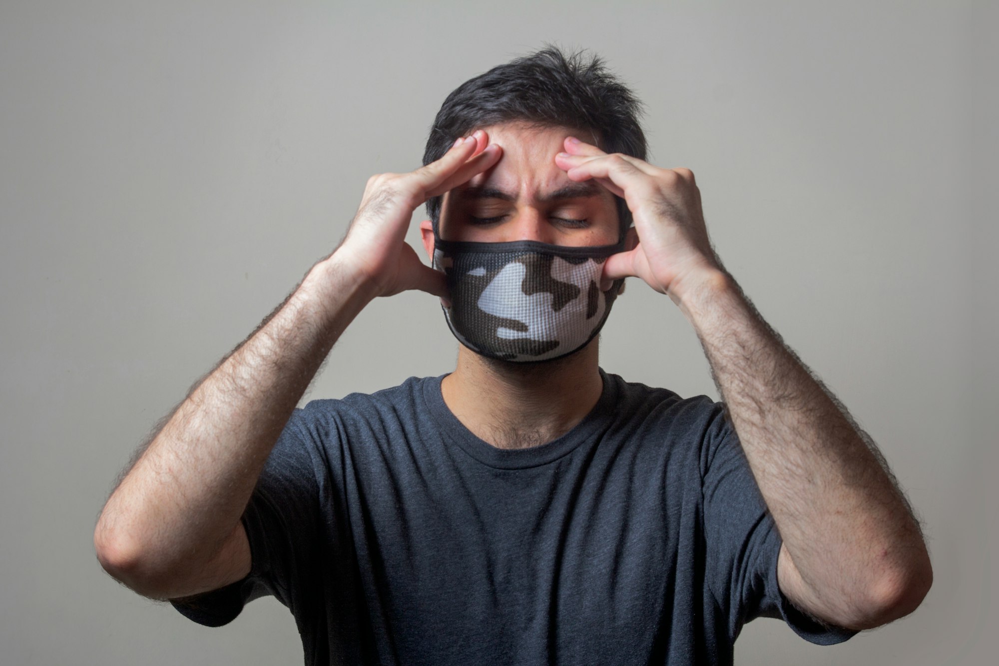 A sick man wearing mask having swear headache