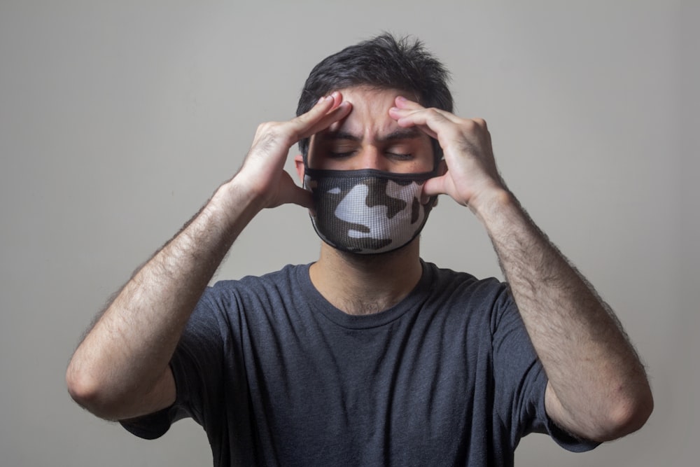 homme en noir t-shirt à col rond portant un masque noir et blanc