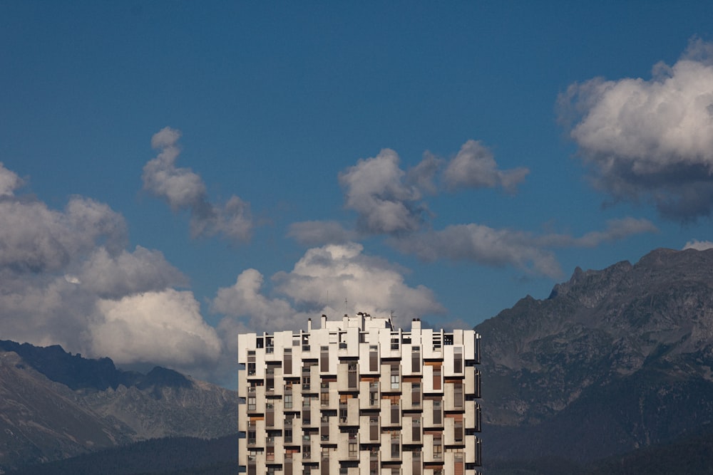 edifício branco e azul perto da montanha sob o céu azul durante o dia