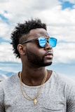 man in gray crew neck shirt wearing blue sunglasses