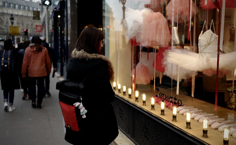 woman in black jacket standing in front of candles